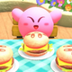 Kirby sits before three burgers with Kirby faces on the buns.